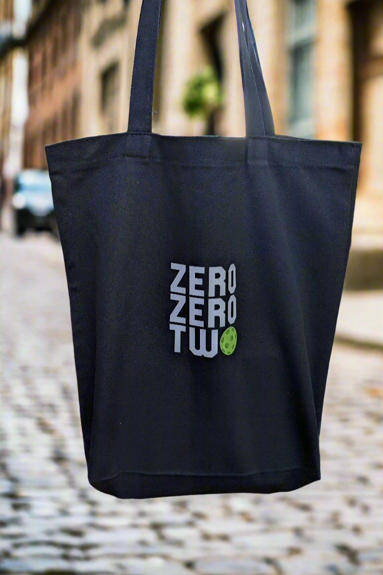 Black tote bag with 'Zero Two' text on a wooden deck